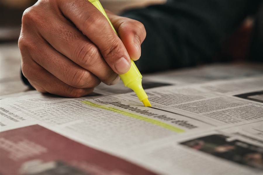 Stabilo kuning menyorot headline di lembaran koran